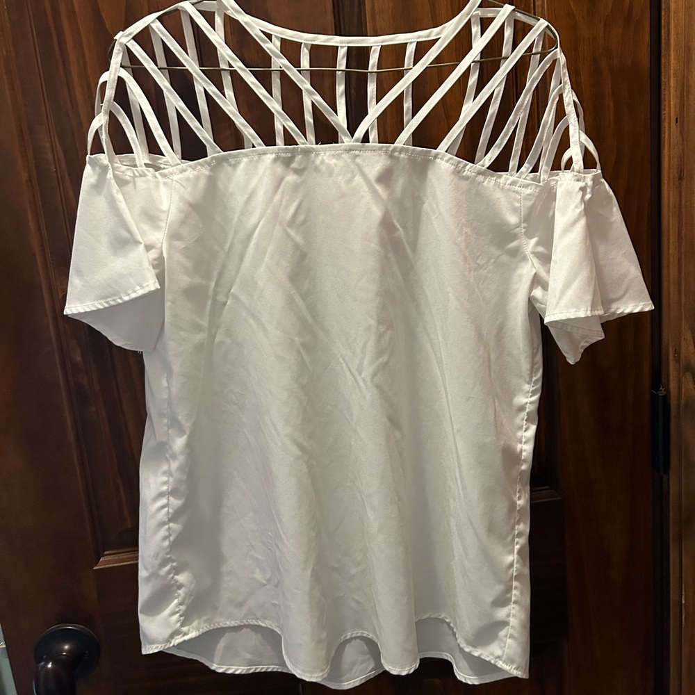 It is a size small white blouse with a nice design on the top of it.